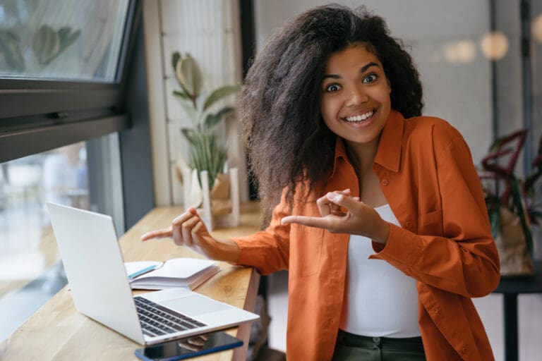 Young,Cheerful,African,American,Woman,Pointing,Two,Fingers,On,Laptop