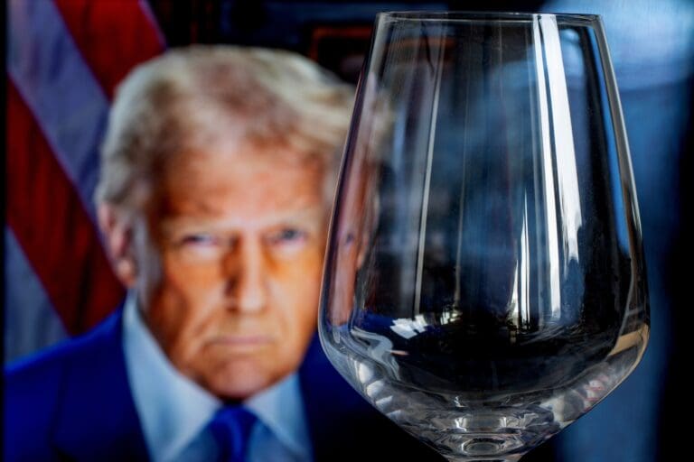 Empty,Wine,Glass,With,A,Blurred,Figure,Of,President,Donald