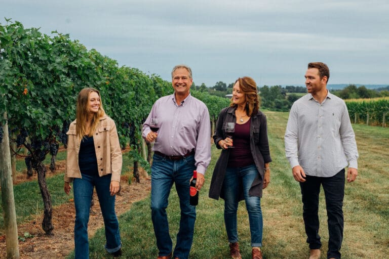 Alexis, Jan, Kim, and Zach Waltz walking in the vineyard photo by Bethany Kramer